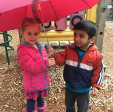 Kids sharing an umbrella